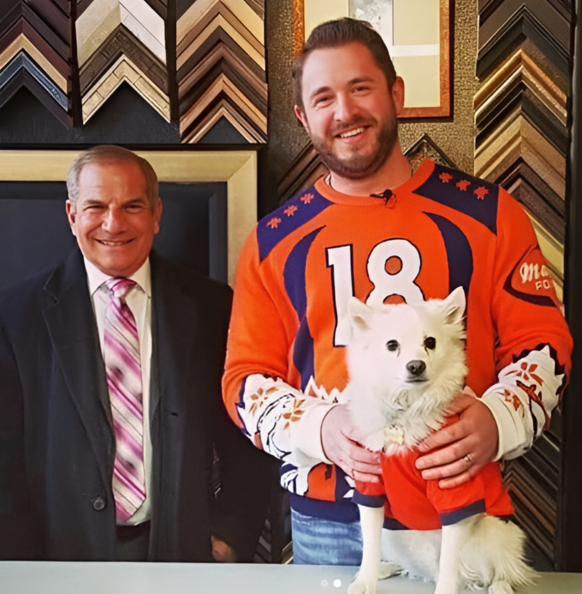 Rick Sallinger posing with the owner of 5280 Custom Framing and Helton the shop mascot